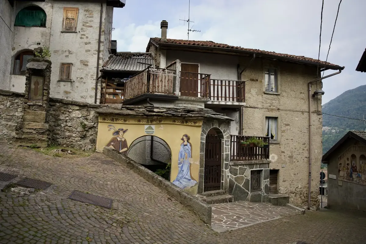 Affresco inserito tra le case del borgo di Parlasco in Valsassina